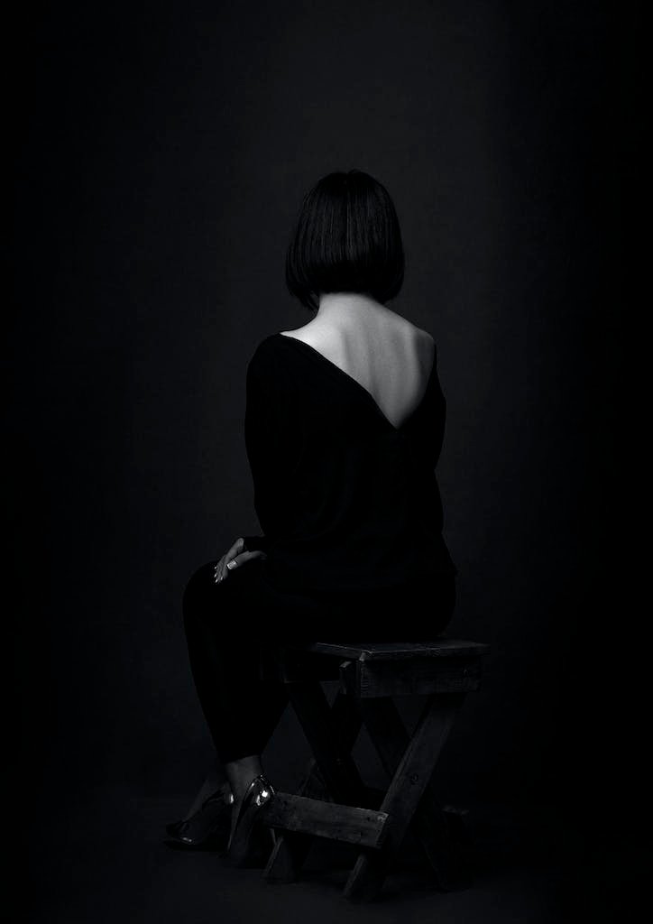 Artistic Photograph of Sitting Woman in Black Shirt