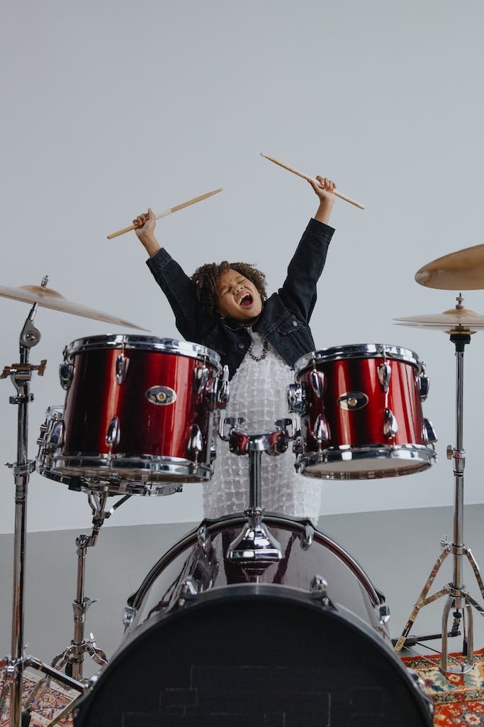 Woman in Black Jacket Playing Drum Set